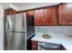 Stainless steel refrigerator in a modern kitchen with wood cabinets at 750 E Northern Ave # 1053, Phoenix, AZ 85020