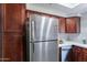 Stainless steel refrigerator in a modern kitchen with wood cabinets at 750 E Northern Ave # 1053, Phoenix, AZ 85020