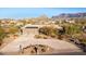 Aerial view of a stunning home with solar panels, a large driveway, and mountain views at 10400 E Breathless Ave, Gold Canyon, AZ 85118