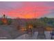 Inviting backyard with lounge chairs under a vibrant sunset sky, perfect for relaxation at 10400 E Breathless Ave, Gold Canyon, AZ 85118