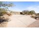 Exterior view of a large home with a spacious driveway and desert landscaping at 10400 E Breathless Ave, Gold Canyon, AZ 85118