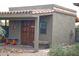 Exterior view of the bunkhouse, featuring a stucco exterior and wooden doors at 10400 E Breathless Ave, Gold Canyon, AZ 85118