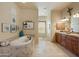 Spa-like bathroom with soaking tub, double vanity, and tile floors at 14597 E Corrine Dr, Scottsdale, AZ 85259