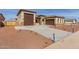 New home exterior featuring a three-car garage and desert landscaping at 17330 W Royal Palm Rd, Waddell, AZ 85355