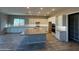 Modern kitchen with white cabinets, grey island, and wood-look tile floors at 17330 W Royal Palm Rd, Waddell, AZ 85355