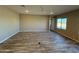 Spacious living room with wood-look tile floors and large windows at 17330 W Royal Palm Rd, Waddell, AZ 85355