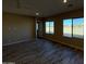 Spacious living room with wood-look tile floors and large windows at 17330 W Royal Palm Rd, Waddell, AZ 85355