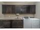 Laundry room with dark cabinets and washer/dryer at 18147 W Sandy Rd, Goodyear, AZ 85338