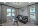 Cozy living room with dark leather couch and large windows at 18147 W Sandy Rd, Goodyear, AZ 85338