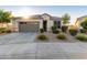 One-story home with gray garage door, landscaping, and a welcoming front porch at 18280 N Piccolo Dr, Maricopa, AZ 85138