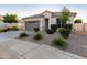 One-story home with gray garage door, landscaping, and a welcoming front porch at 18280 N Piccolo Dr, Maricopa, AZ 85138