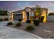 One-story home with gray garage door, landscaping, and a welcoming front porch at 18280 N Piccolo Dr, Maricopa, AZ 85138