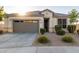 One-story home with gray garage door, landscaping, and a welcoming front porch at 18280 N Piccolo Dr, Maricopa, AZ 85138