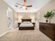 Main bedroom featuring a ceiling fan, large windows and ensuite bath at 18280 N Piccolo Dr, Maricopa, AZ 85138