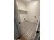 Laundry room with patterned tile floor and built-in shelving at 19009 W Maryland Ave, Waddell, AZ 85355