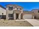 Two-story house with light beige exterior, two-car garage, and desert landscaping at 19436 W Valle Vista Way, Litchfield Park, AZ 85340