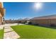 Spacious backyard with artificial turf, patio, fire pit, and built-in BBQ at 19651 W Monterey Way, Buckeye, AZ 85396