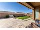 Landscaped backyard with artificial turf, fire pit, and patio at 19651 W Monterey Way, Buckeye, AZ 85396