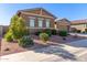 Tan two-story house with a three-car garage and desert landscaping at 19651 W Monterey Way, Buckeye, AZ 85396