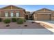 Tan two-story house with a three-car garage and desert landscaping at 19651 W Monterey Way, Buckeye, AZ 85396