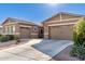 Tan two-story house with a three-car garage and desert landscaping at 19651 W Monterey Way, Buckeye, AZ 85396