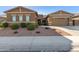 Tan two-story house with a three-car garage and desert landscaping at 19651 W Monterey Way, Buckeye, AZ 85396