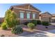 Tan two-story house with a three-car garage and desert landscaping at 19651 W Monterey Way, Buckeye, AZ 85396