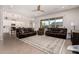 Spacious living room with leather sofas, a large window, and view into kitchen at 19651 W Monterey Way, Buckeye, AZ 85396