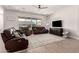 Relaxing living room featuring brown leather couches and a large sliding glass door at 19651 W Monterey Way, Buckeye, AZ 85396