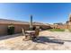 Backyard patio with seating area and umbrella, next to grassy area at 19651 W Monterey Way, Buckeye, AZ 85396