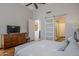 Main bedroom with dresser, TV and barn door to bathroom at 20802 N Grayhawk Dr # 1173, Scottsdale, AZ 85255