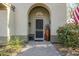 Inviting entryway with arched doorway, security screen door, and mature landscaping at 20802 N Grayhawk Dr # 1173, Scottsdale, AZ 85255