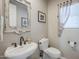 Updated powder room with pedestal sink, toilet and decorative mirror at 20802 N Grayhawk Dr # 1173, Scottsdale, AZ 85255