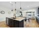 Open concept kitchen island with granite countertops, looking into living room at 25536 S 230Th St, Queen Creek, AZ 85142