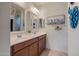 Double vanity bathroom with two sinks, mirrors, and ample storage at 25940 W Oraibi Dr, Buckeye, AZ 85396