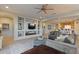 Bright and airy living room with built-in shelving and a ceiling fan at 25940 W Oraibi Dr, Buckeye, AZ 85396