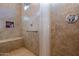 Large tiled shower with built-in seat and grab bar at 25940 W Oraibi Dr, Buckeye, AZ 85396