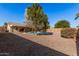 Relaxing backyard with a pebble-textured ground, a swimming pool, and a large shade tree at 2605 S 80Th Ave, Phoenix, AZ 85043