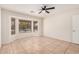 Bedroom with large window overlooking pool, ceiling fan, and tile floors at 2605 S 80Th Ave, Phoenix, AZ 85043