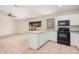 Open kitchen with island, view into adjacent living area, and tile flooring at 2605 S 80Th Ave, Phoenix, AZ 85043