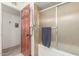 Clean bathroom with shower/tub combo and a door leading to another room at 2618 W Surrey Ave, Phoenix, AZ 85029