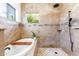 Spa-like bathroom with a soaking tub, walk-in shower, and tiled walls at 28602 N 58Th St, Cave Creek, AZ 85331