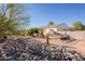 Landscaped backyard with rock retaining walls and a covered patio area at 28821 N Ashbrook Ln, Queen Creek, AZ 85144