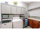 Bright laundry room, featuring granite countertops and ample cabinetry at 28821 N Ashbrook Ln, Queen Creek, AZ 85144