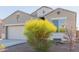 Light brown house with a two-car garage and flowering bushes at 30905 W Fairmount Ave, Buckeye, AZ 85396