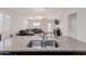 Kitchen island with granite countertop and double sink overlooking living room at 30905 W Fairmount Ave, Buckeye, AZ 85396