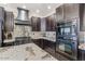 Modern kitchen with granite counters, dark cabinets, and a gas cooktop at 3141 S 83Rd Cir, Mesa, AZ 85212