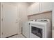 Bright laundry room, featuring washer, dryer, and overhead cabinets at 3189 N Excursion Ln, Casa Grande, AZ 85122