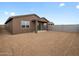 View of backyard featuring covered patio and dirt yard surrounded by block fencing and clear blue sky at 3201 E Hayden Rose Ave, San Tan Valley, AZ 85143