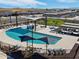 A high angle of the community pool with splashpad feature, lounge chairs, and shady umbrellas at 3201 E Hayden Rose Ave, San Tan Valley, AZ 85143